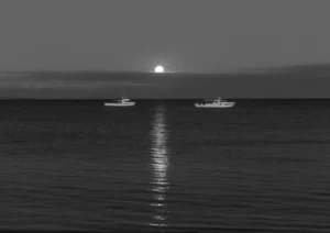 two fishing boats in the moonlight