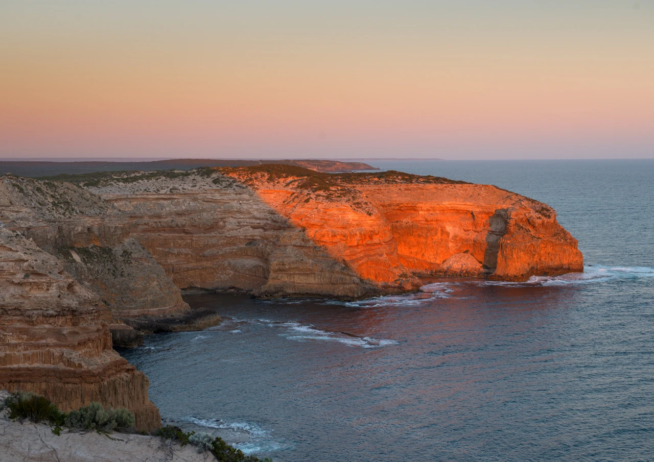 Massive cliffs in the setting sun. Cape Spencer