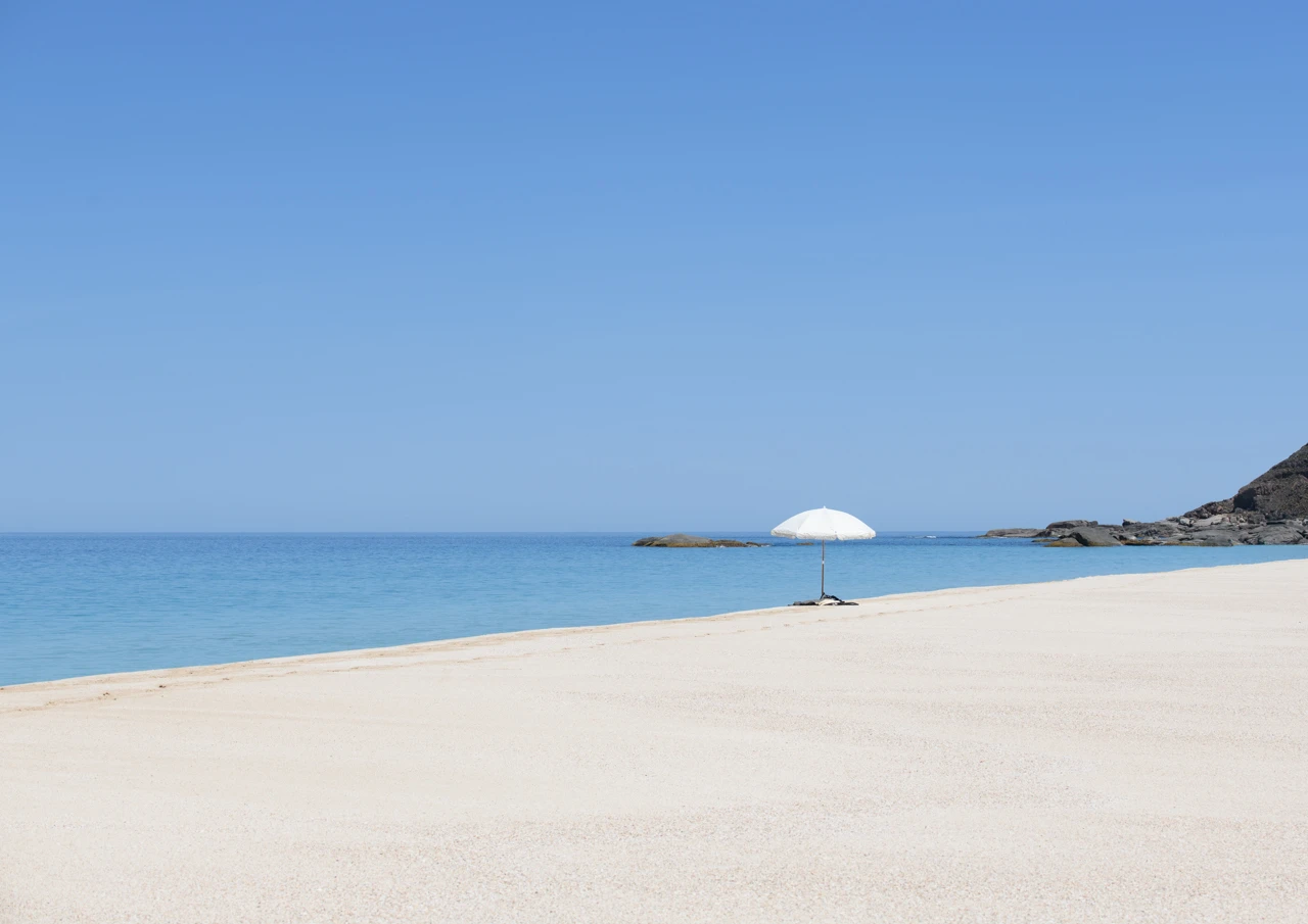 Isolated beach with white umbrella