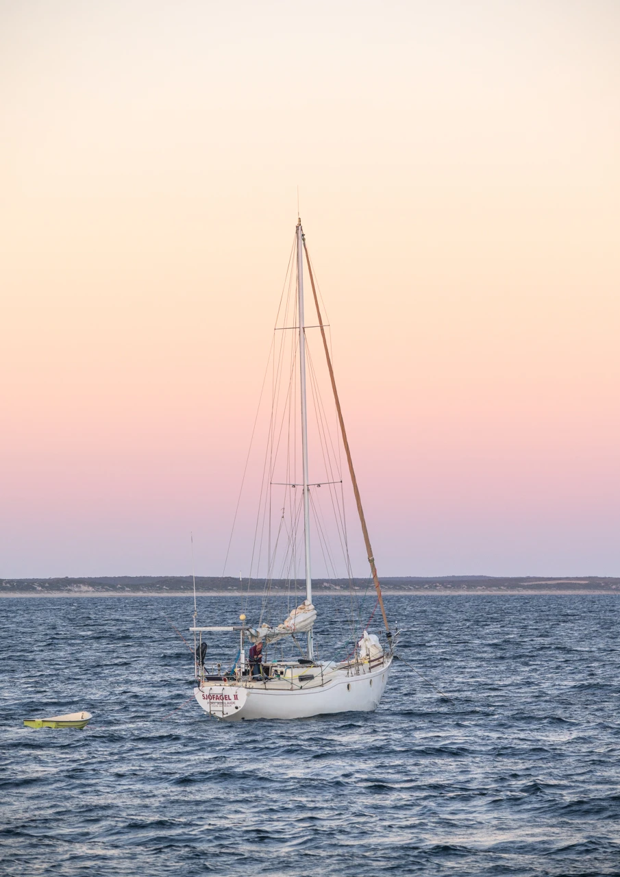 Beautiful pink evening and a yacht moored in the bay