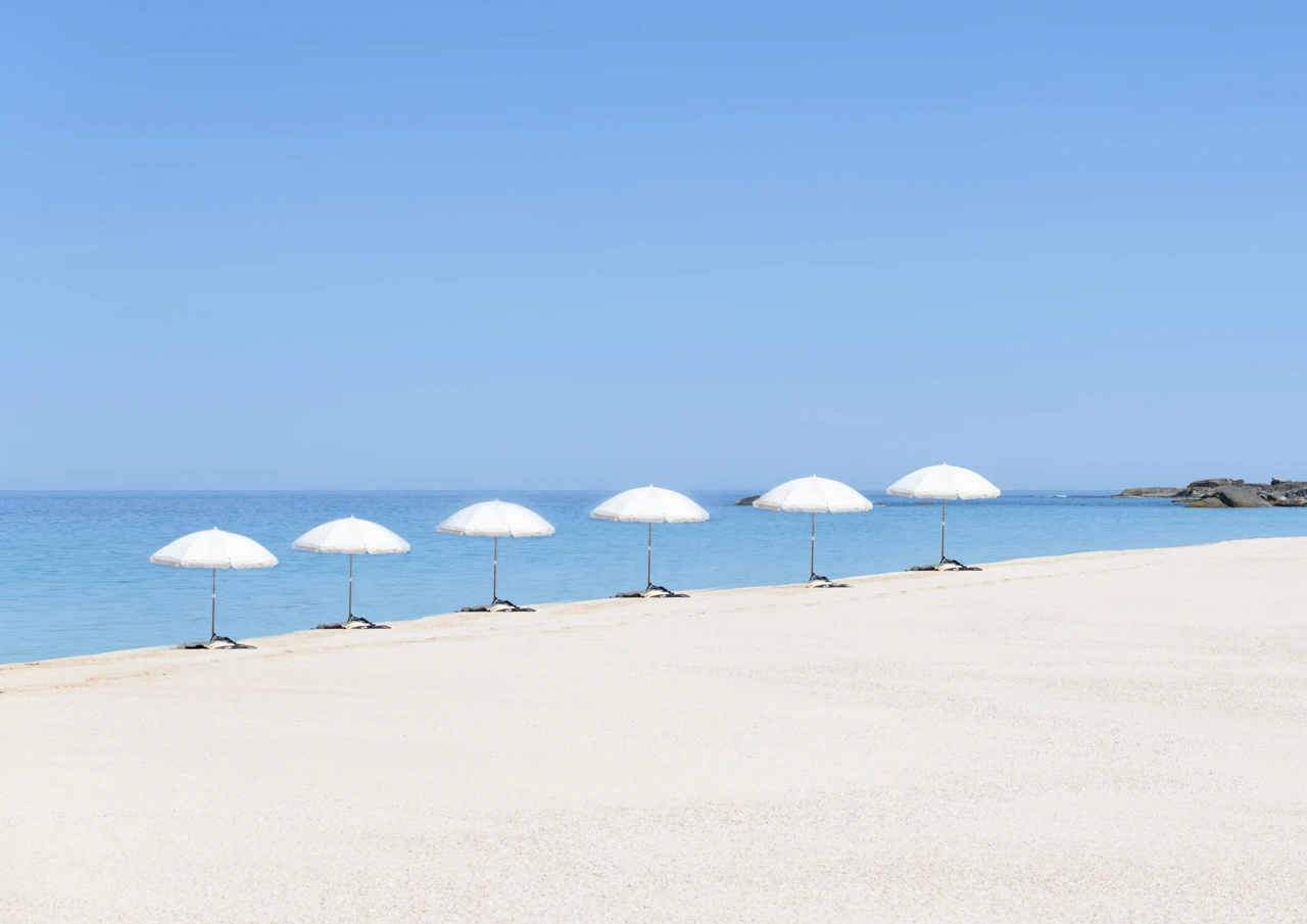 White sun umbrellas in a line