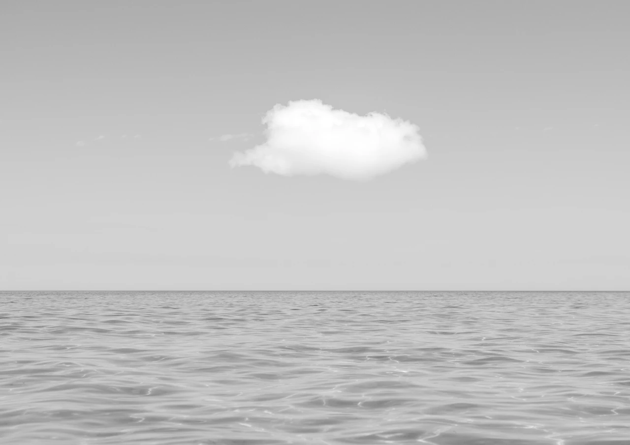 Black and white ocean with one white cloud